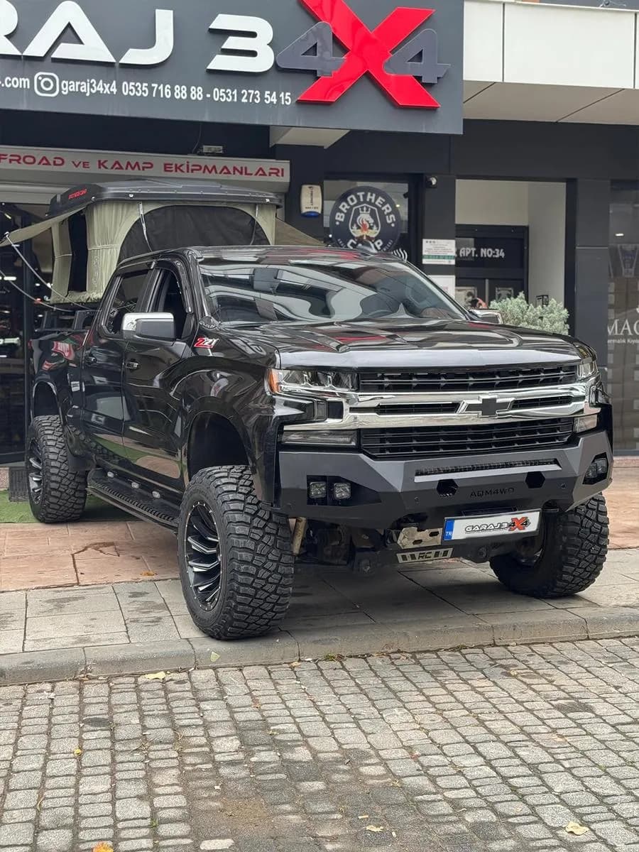 Garaj34x4 tabelasının altında ön demir tamponlu siyah Chevrolet Silverado